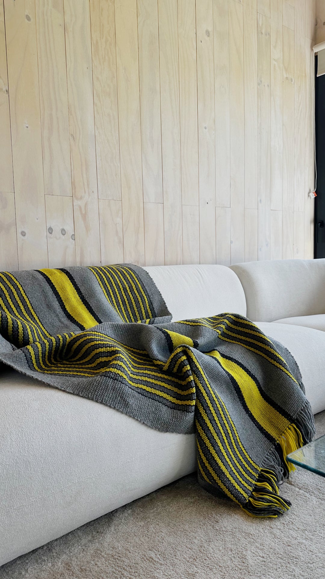 Ranco Slate and Citrus wool throw rug draped over a sofa – 100% sheep's wool, Andean Home Australia