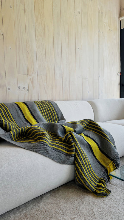Ranco Slate and Citrus wool throw rug draped over a sofa – 100% sheep's wool, Andean Home Australia